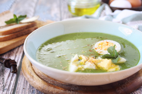 Green pea soup with spinach, olive oil, sesame and half boiled egg
