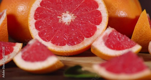 Slices of ripe juicy grapefruit slowly rotate.