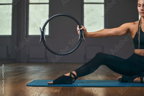 The girl is training her hands with a fitness expander in the gym, doing push-ups, training the upper body, shoulders, chest, triceps. Fitness motivation, copy space.