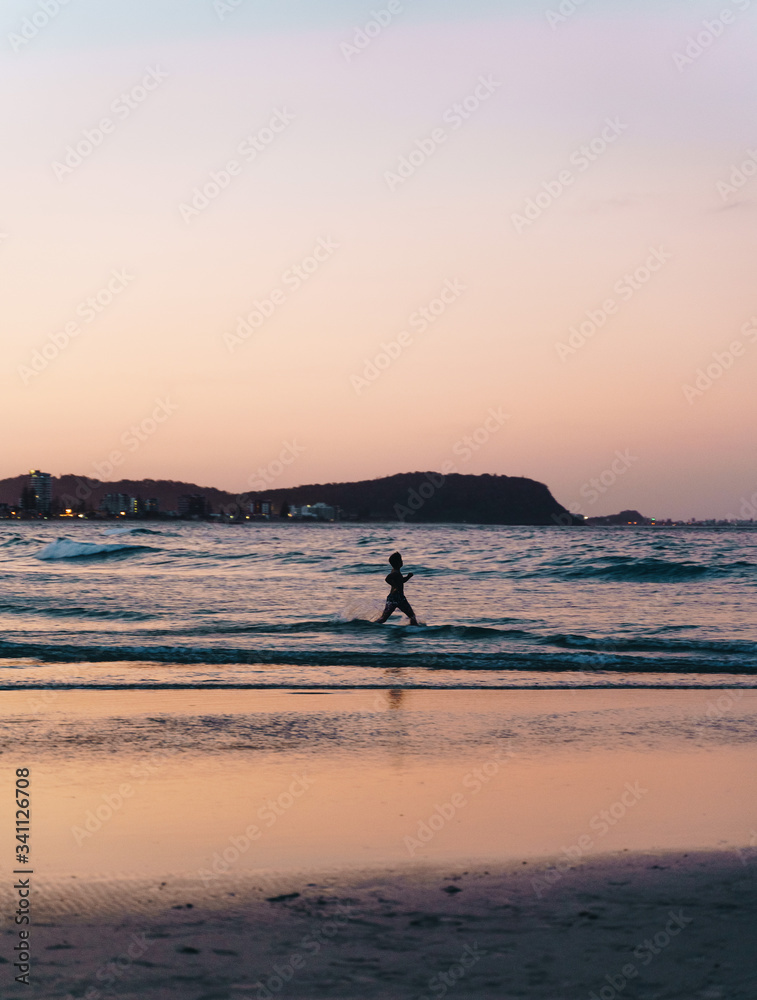 silhouette of a man swimming on the Currumbin beach