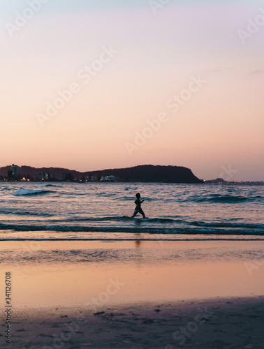 Fototapeta Naklejka Na Ścianę i Meble -  silhouette of a man swimming on the Currumbin beach