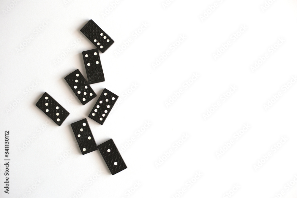 Black dominoes lie on a white background, top view. Table game. Place for text Black dominoes lie on a white background, top view. Table game. Place for text