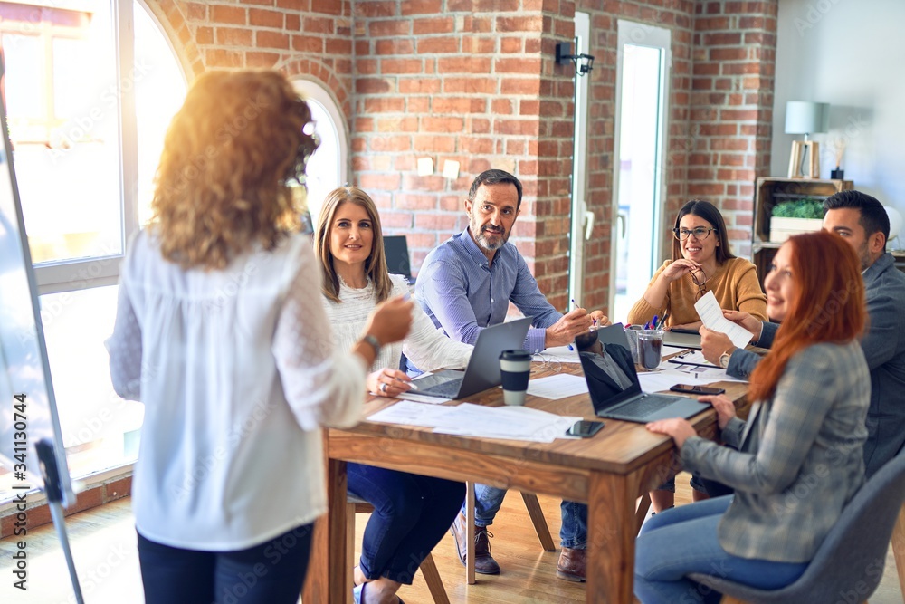 Group of business workers working together in a meeting. One of them making presentation to colleagues at the office Group of business workers working together in a meeting. One of them making presentation to colleagues at the office