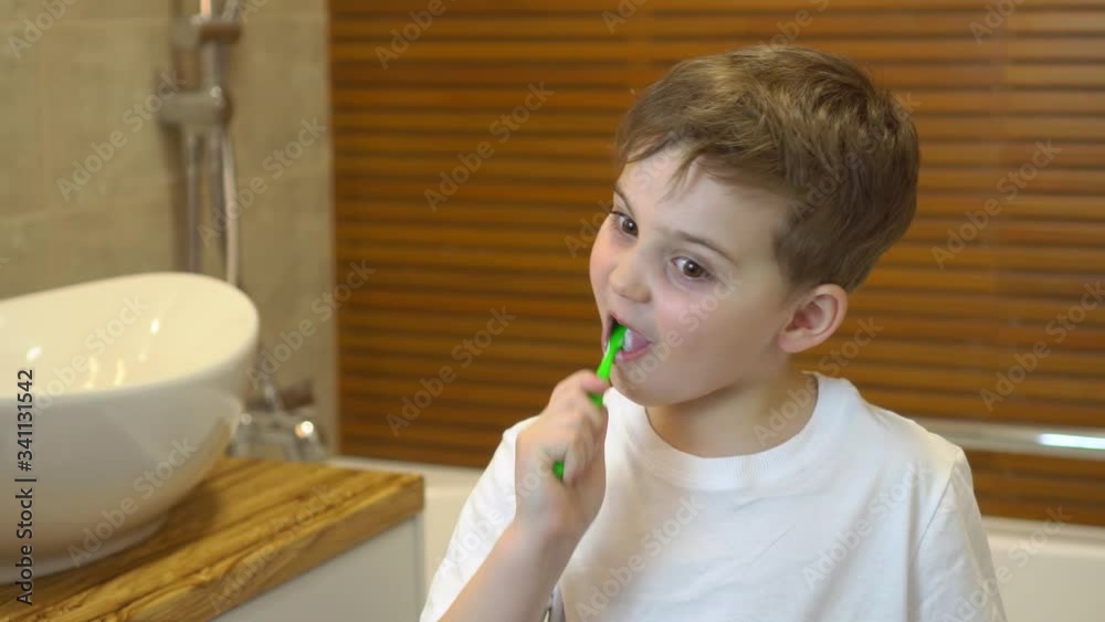 boy cleaning his teeth in a bathroom boy cleaning his teeth in a bathroom