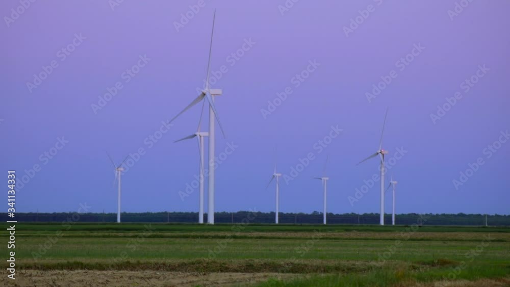 View of windmills spinning at sunset, windmills creating green energy, Eco-friendly electricity. View of windmills spinning at sunset, windmills creating green energy, Eco-friendly electricity.