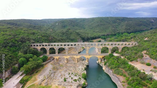 Low altitude aerial of Pont du Gard is an ancient Roman aqueduct that crosses the Gardon River near the town of Vers-Pont-du-Gard in southern France and popular tourist destination 4k
