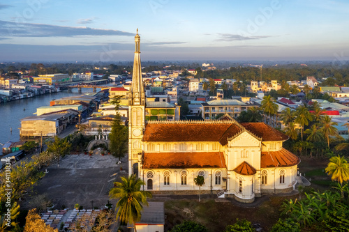 Aerial view of the famous Cai Be church in the Mekong Delta, Roman architectural style. In front is Cai Be floating market, Tien Giang, Vietnam
