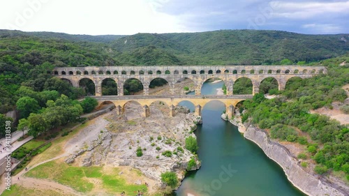 Aerial bird view footage Pont du Gard is ancient Roman aqueduct that crosses Gardon River near towns of Remoulins Avignon and Nimes in southern France 4k