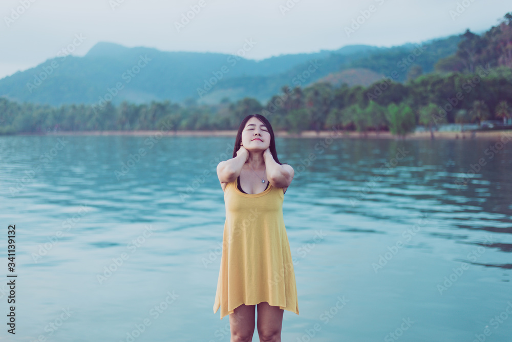 Happy asian woman standing with hands on head at the sea,Enjoying in Nature,Freedom concept Happy asian woman standing with hands on head at the sea,Enjoying in Nature,Freedom concept