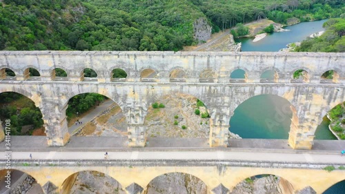 Low altitude aerial of Pont du Gard is an ancient Roman aqueduct that crosses the Gardon River near the town of Vers-Pont-du-Gard in southern France and popular tourist destination 4k