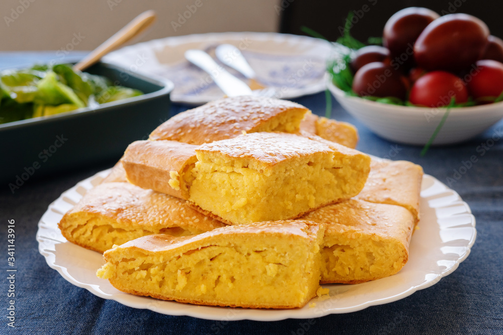 Close up view on cornbread corn pone in a white plate on the table covered with sesame seed organic vegetarian food vegan Close up view on cornbread corn pone in a white plate on the table covered with sesame seed organic vegetarian food vegan