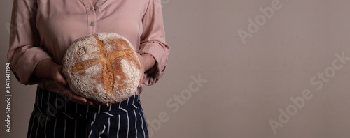 Banner Bela mulher branca ocidental segurando um Pão Italiano de fermentação natural rústica photo