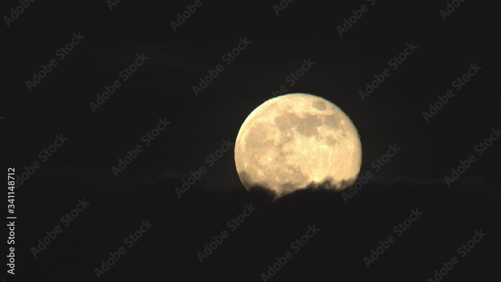 Detailed full moon rising above clouds close up.mov