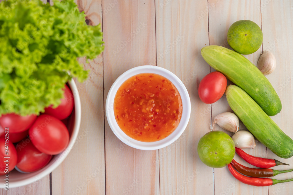 Cucumber, lemon, tomato, garlic, chili with sauce on the wood floor. Cucumber, lemon, tomato, garlic, chili with sauce on the wood floor.