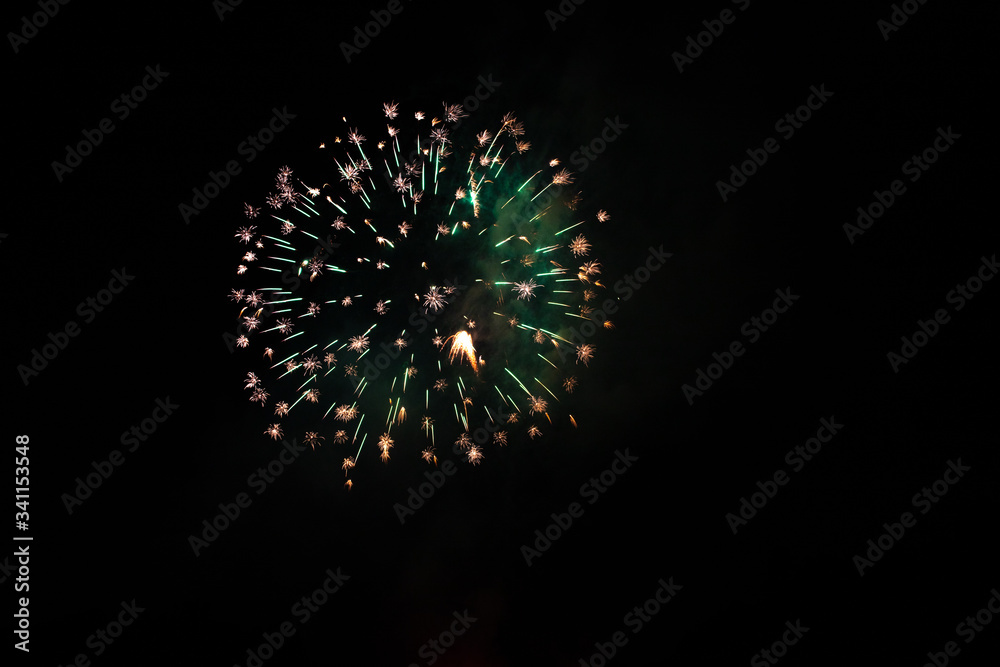 Green and orange Dragon's Eggs firework exploding in the sky with copy space Green and orange Dragon's Eggs firework exploding in the sky with copy space