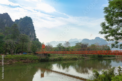 Landcape of muontain in vangvien Laos with long orange bridge and The beautiful mountains rang as a backdrop