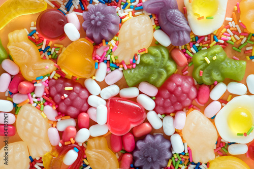 Foto Flatlay of assorted jelly fruits and sprinkles textured background