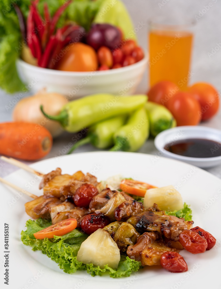 BBQ with a variety of meats, complete with tomatoes and bell peppers on a white plate. BBQ with a variety of meats, complete with tomatoes and bell peppers on a white plate.