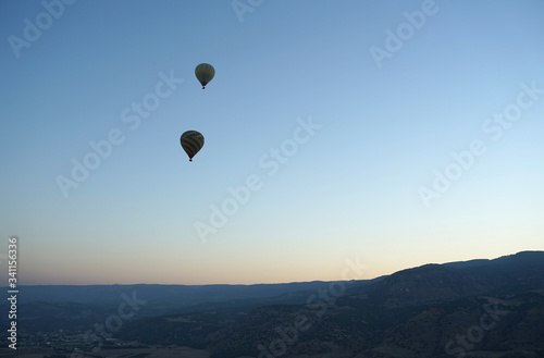 Panoramic view of mountain landscape with hot air balloon floating in the sky