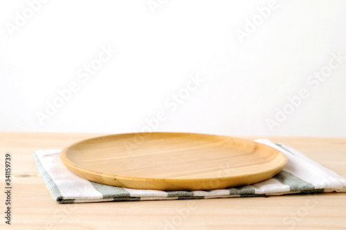 Empty round wooden plate on wood table background, food display montage