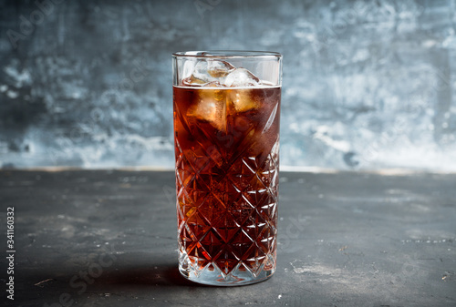 Cold cola beverage in glass with ice. Selective focus. Shallow depth of field.