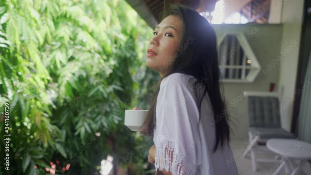 young happy and beautiful Asian Korean woman having morning coffee or tea at hotel terrace curtains door or home balcony smiling relaxed and cheerful
young happy and beautiful Asian Korean woman having morning coffee or tea at hotel terrace curtains door or home balcony smiling relaxed and cheerful
