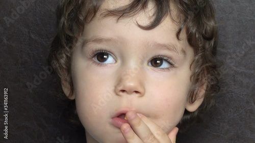 Adorable little boy looks interested while watching tv
