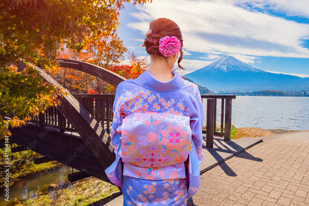 Geisha admires mount Fuji and the lake. Japanese girl in a kimono on the  background of Fujiyama. Trip to Kawaguchiko. Autumn in Japan. Autumn  landscape and Japanese woman in national clothes. Stock