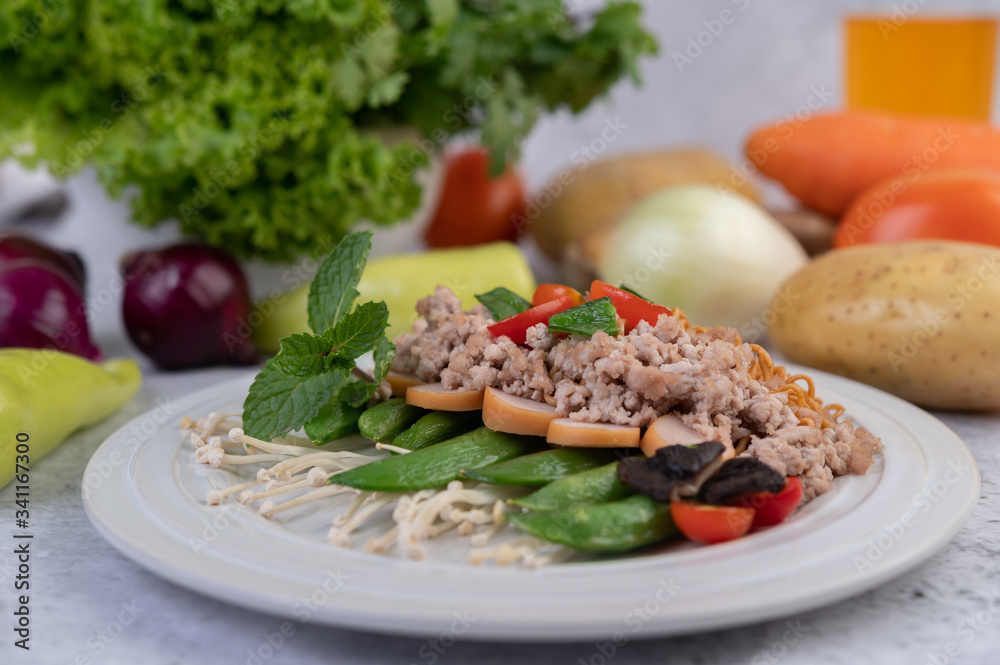 Stir-fried noodles with minced pork, edamame, tomatoes and mushrooms in a white plate.