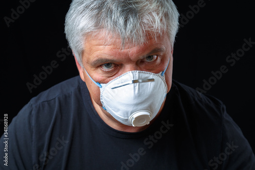 An elderly European man wears a protective mask against the virus. Pandemic Covid-19.