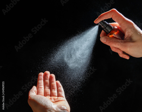 Woman's hands spray an antiseptic to protect against the virus. Pandemic Covid-19.
