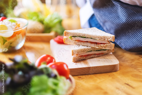 Closeup image of a female chef cooking whole wheat sandwich in kitchen