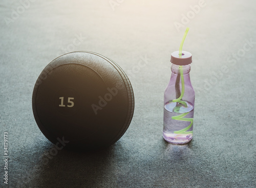 Close-up the 15 kg slamball and water bottle with copy space. Sport and recreation concept. photo