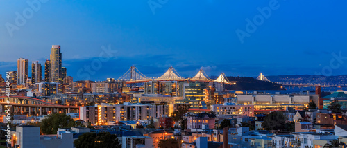 San Francisco skyline night panorama with city lights  the Bay Bridge and trail lights