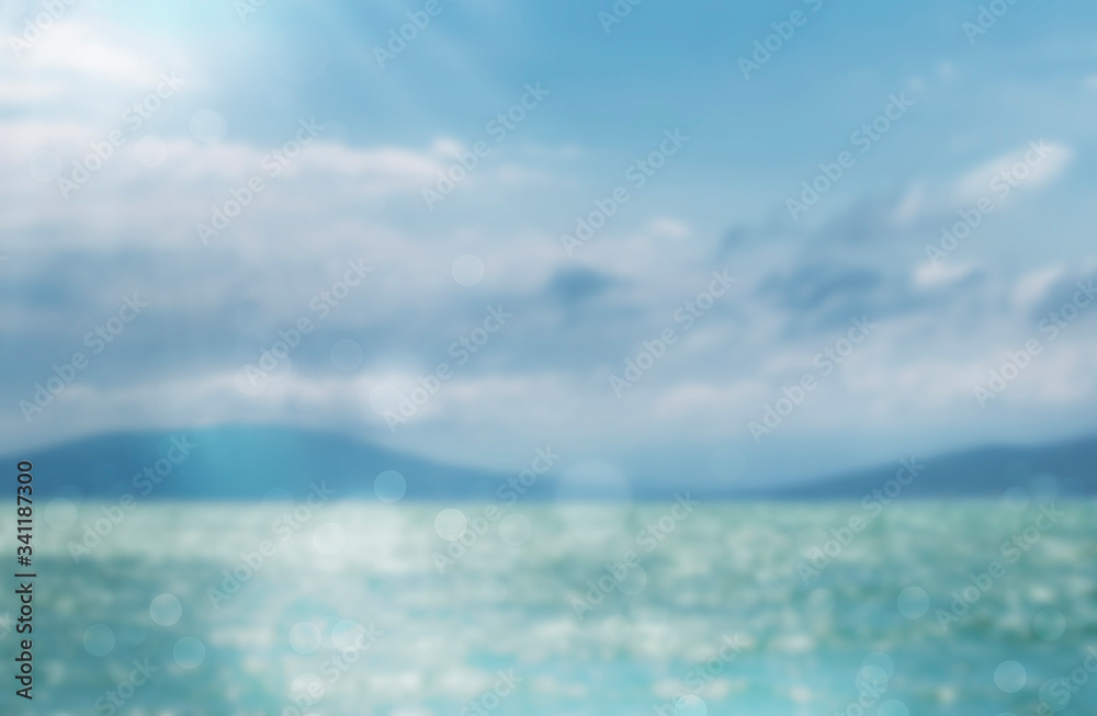 Fototapeta premium Blurred summer natural marine tropical blue background and sunbeams of light. Sea and sky with white clouds. Copy space, summer vacation concept