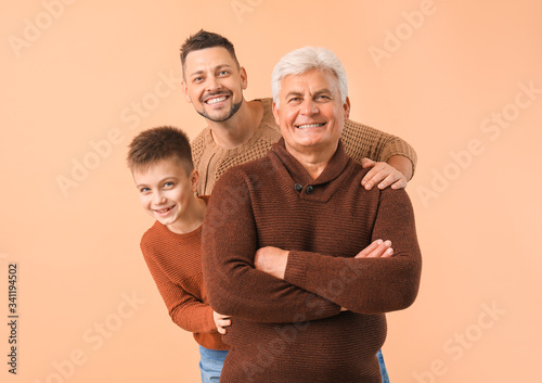 Man with his father and son on color background