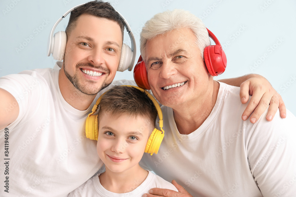 Man with his father and son taking selfie on color background Man with his father and son taking selfie on color background