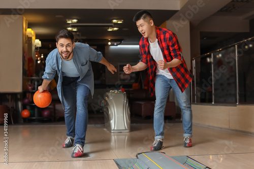 Friends playing bowling in ...