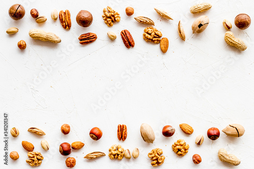 Nuts background - healthy snacks concept - on white table top-down frame copy space