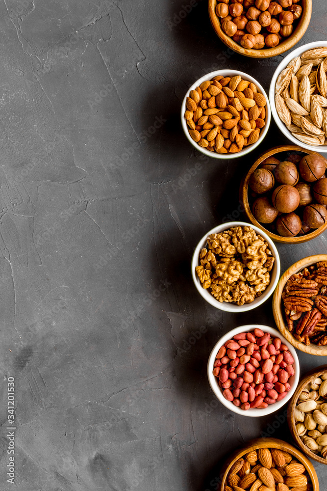 Nuts set in bowls on grey background top-down frame copy space Nuts set in bowls on grey background top-down frame copy space