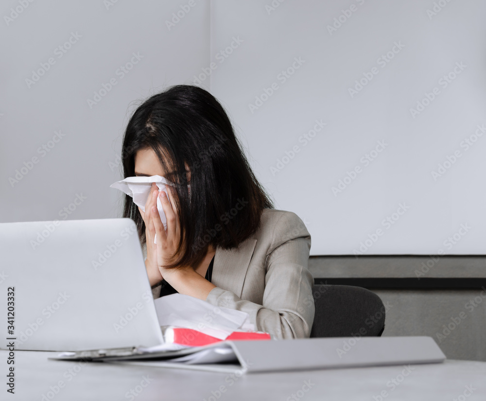 Sick business woman sneezing while working in meeting room. Working and seasonal inflection concept. Sick business woman sneezing while working in meeting room. Working and seasonal inflection concept.