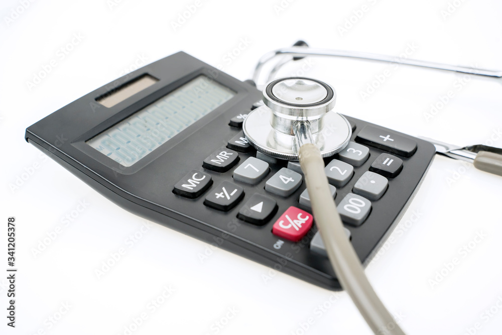 Closeup of stethoscope and calculator on table Closeup of stethoscope and calculator on table