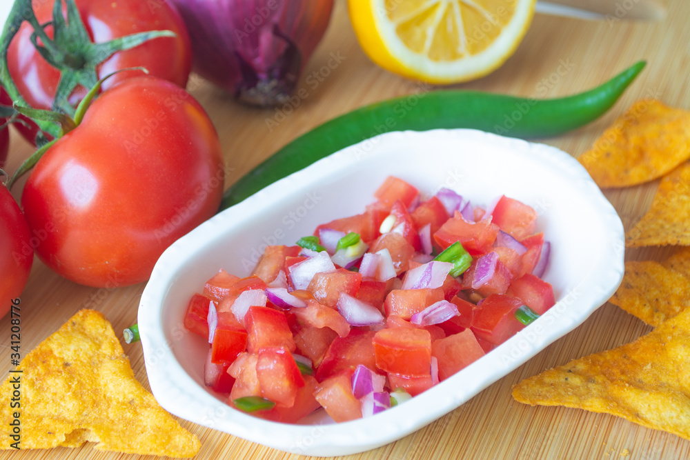 Mexican salsa pico de gallo with tomatoes, red onions, spicy green jalapeno pepper, lemon and nacho corn chips