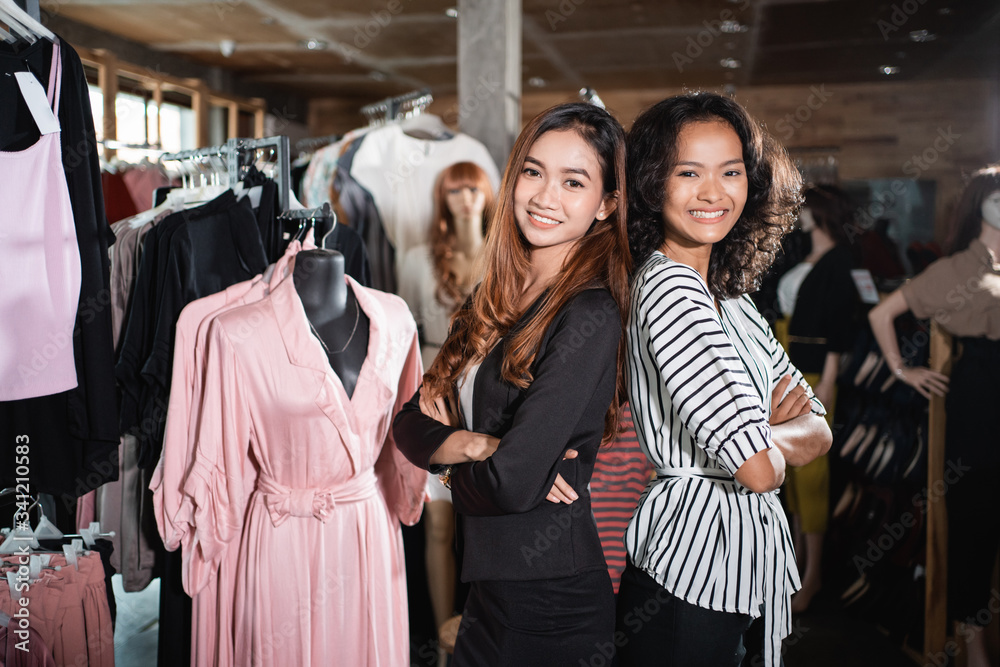 fashion shop seller asian woman standing back to back with partner and crossed arm fashion shop seller asian woman standing back to back with partner and crossed arm
