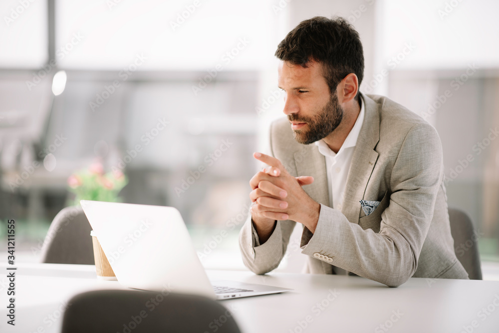 Businessman in office. Handsome man working on lap top.
Businessman in office. Handsome man working on lap top.