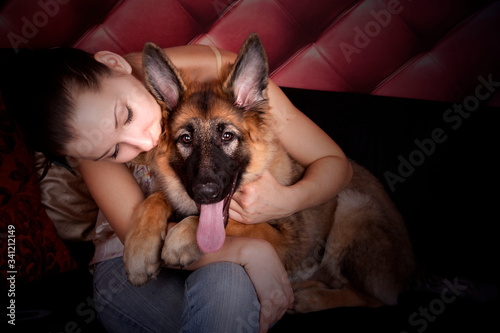 Cute Portrait of Happy Young Woman hugging and cuddling with the Lovely German Shepherd - Sheepdog Puppy.The best friends concept.