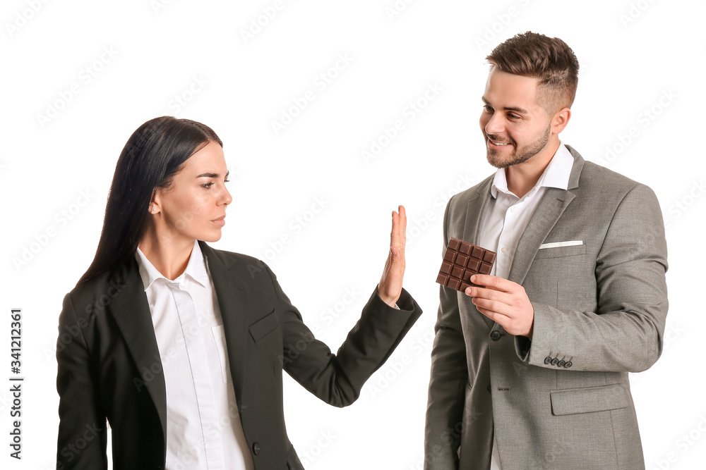 Young woman refusing to eat chocolate against white background Young woman refusing to eat chocolate against white background