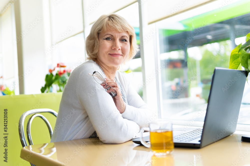 A woman is working with a laptop at a table in the room A woman is working with a laptop at a table in the room