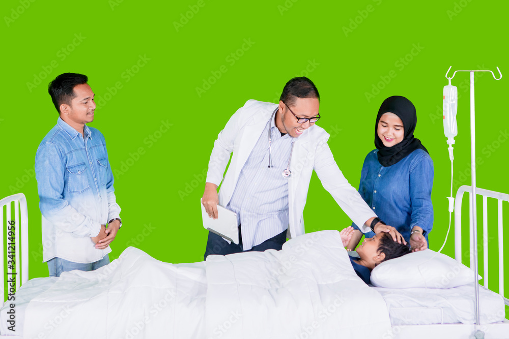 Obraz premium Pediatrician checking boy in studio with parents