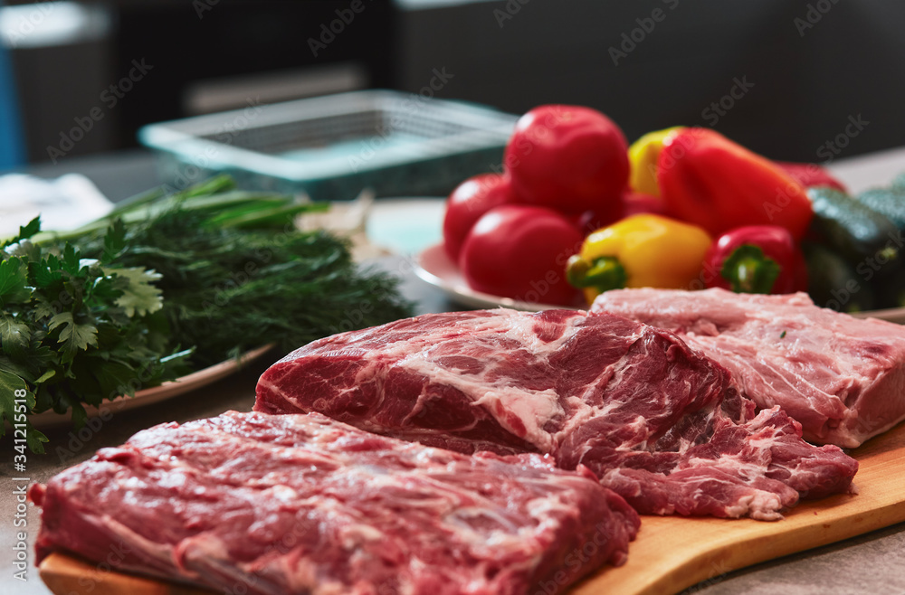 Several pieces of beef meat are lying on a board.